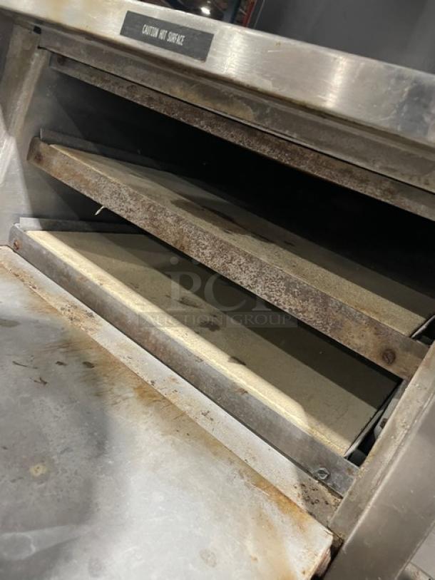 Bakers Pride P18 stainless steel double deck pizza oven in used condition, showing interior racks and caution label. 120V electric.