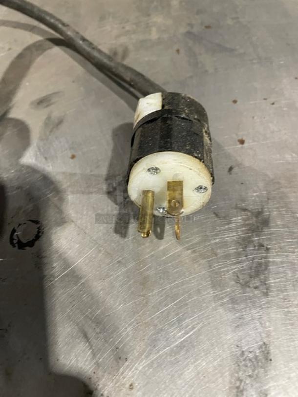 Close-up of a power plug for a Bakers Pride P18 countertop pizza oven, showing a three-prong connector.