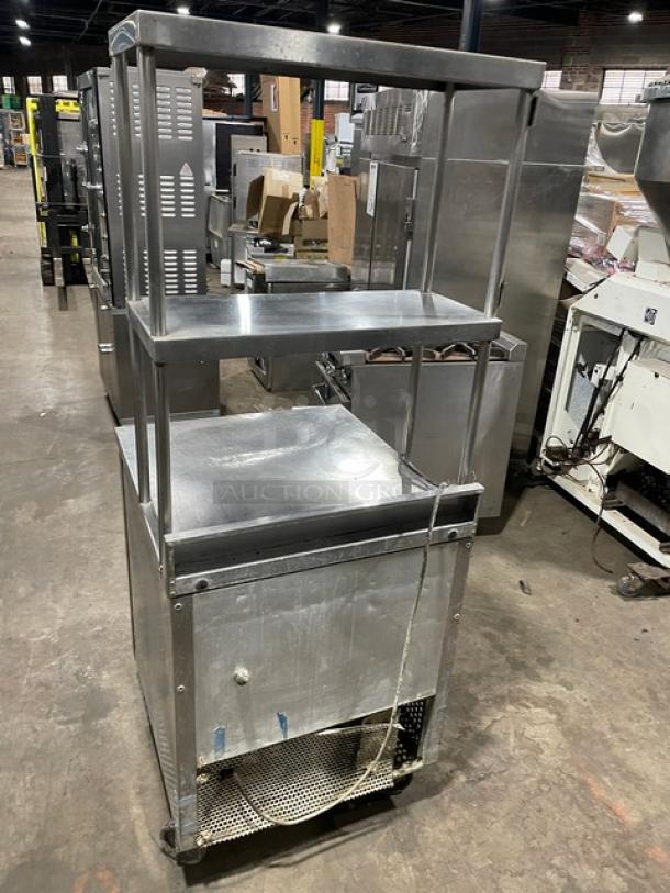 True TWT-27 stainless steel worktop refrigerator with single door, backsplash, double overhead shelf, and casters.