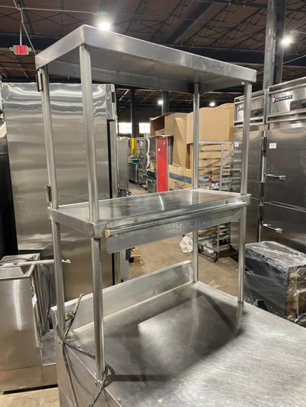 True TWT27 stainless steel single door worktop refrigerator with backsplash, double overhead shelf, poly coated rack, on casters.