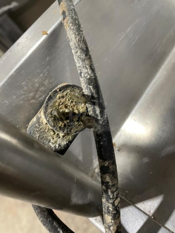 Damaged power cord of True TWT-27 refrigerator, showing heavy wear. Visible metal casing, likely indicating underlying issues.