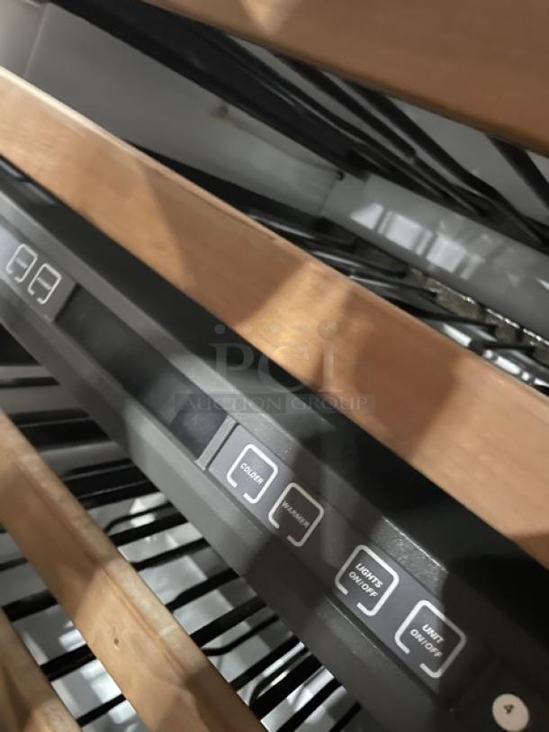 Sub-Zero Model 424 wine cooler detail, showing control panel and wooden shelves. Stainless steel, dual zone, single glass door.