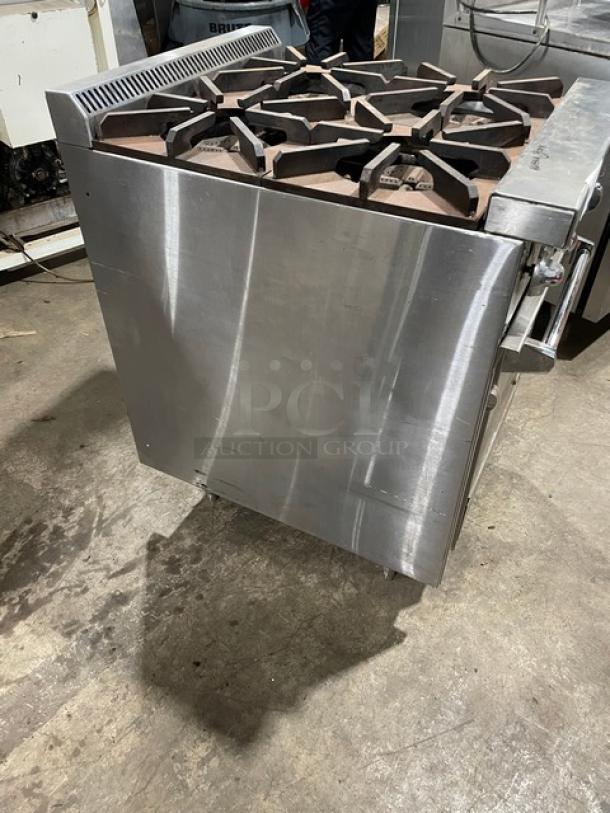 Jade Range stainless steel gas 4-burner oven combo, model JBR424, features a wired oven rack, on legs, in used condition.