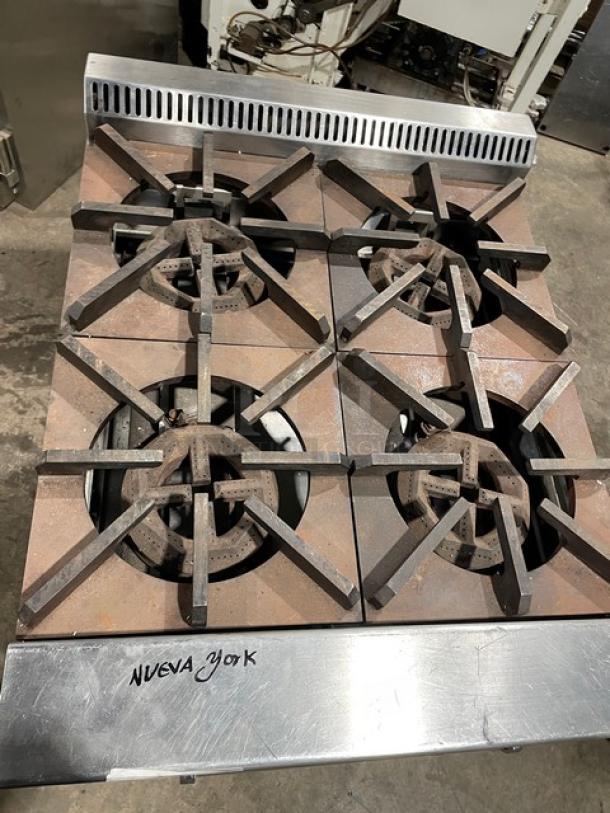 Jade Range 4-burner commercial gas range/oven, model JBR424, with wired oven rack, on legs, stainless steel, marked "Nueva York".