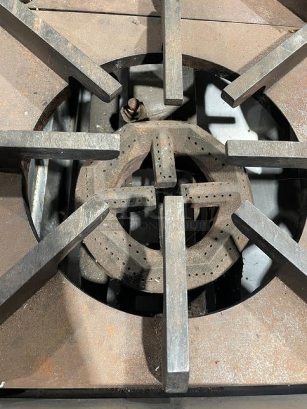 Jade Range JBR424 stainless steel gas 4-burner range/oven combo, model JBR-4-24. Features wired oven rack, on legs, some visible rust.