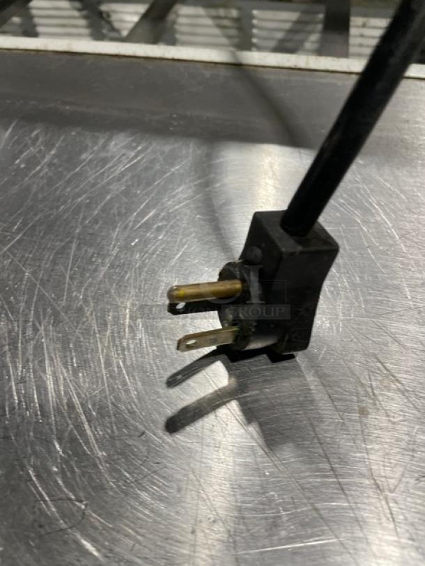 Three-prong plug on stainless steel surface of Beverage-Air Elite Series refrigerated prep table, model SPE72-18.