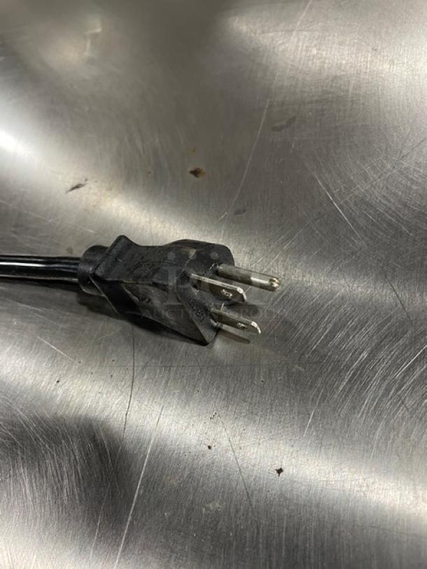 Three-prong plug of Alto-Shaam 750-CTUS holding cabinet on stainless steel surface. Model: 750-CTUS, 208-240V, 1 phase.