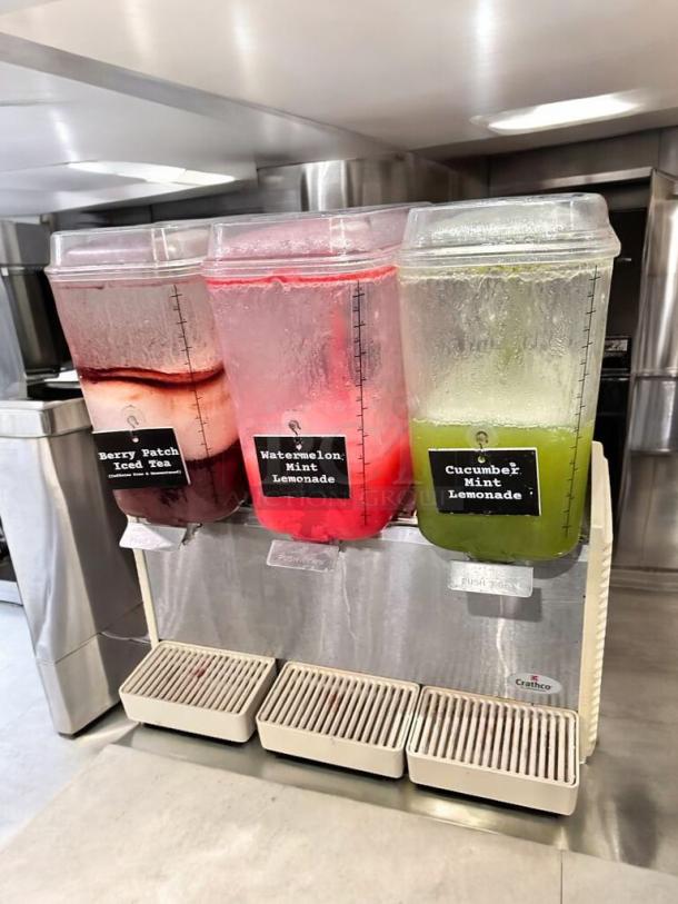 Crathco D35-4 Beverage Dispenser, 4-flavor, outstanding condition, visible labels: Berry Peach Iced Tea, Watermelon Mint Lemonade, and Cucumber Mint Lemonade, 115V, fully tested, working.