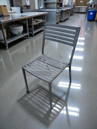 Commercial-grade metal patio chair in immaculate condition, slatted design, durable, fully inspected, ready for outdoor use.