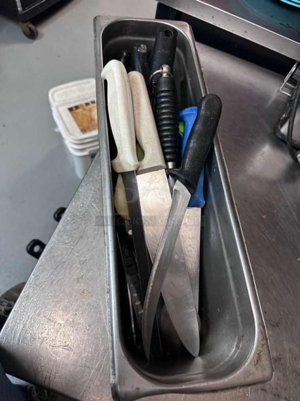 Assorted commercial kitchen knives in premium condition, various brands and models, stored in a metal holder, fully inspected.