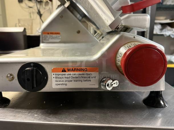 Berkel B12-SLC 12" gravity-feed meat slicer, outstanding condition, with 1/2 HP motor. Visible calibration and warning labels.