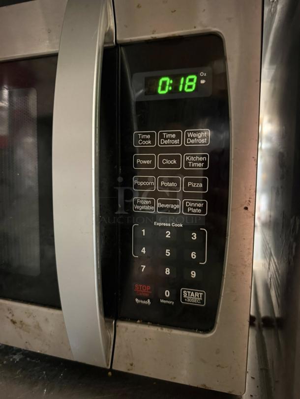 Farberware Professional 1.3 Cu. Ft. 1000-Watt countertop microwave, tested and working, showing control panel with preset options.