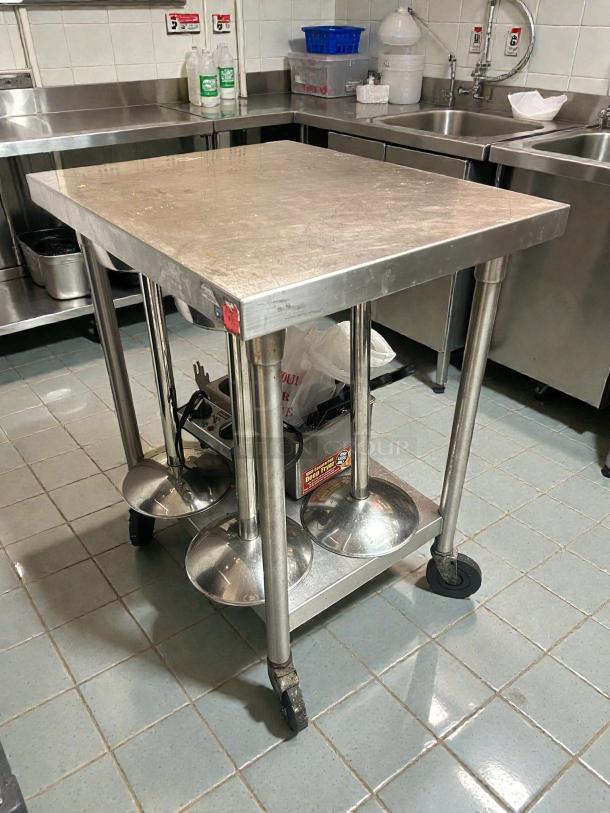 Immaculate Omniteam 24" x 24" stainless steel work table with casters, smooth rolling, tested, ready, kitchen setting.