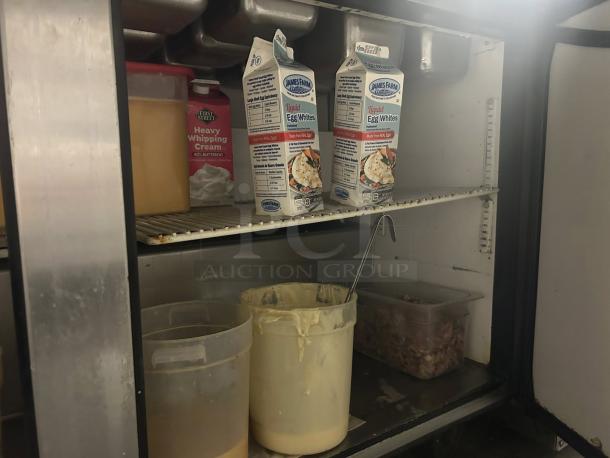 Interior view of True TSSU-60-24M-B-ST-HC prep table, housing food cartons and containers. Shelving and contents shown.