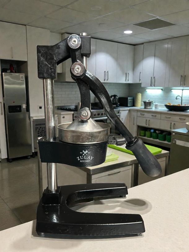 Zulay Kitchen cast-iron manual orange juice squeezer, heavy-duty, robust condition, with visible brand label.