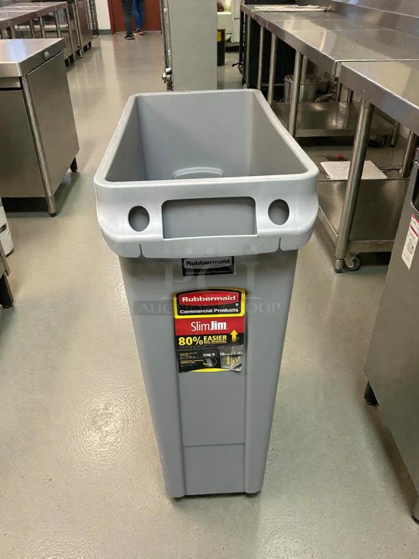 Rubbermaid Slim Jim 23-Gallon Grey Trash Receptacle in immaculate condition, clean, with logo and label, ready for use.