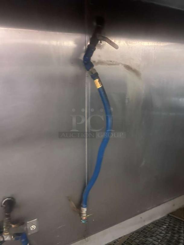 Prime condition commercial gas connector hose, blue, fully inspected, attached to metal wall, ready for use.