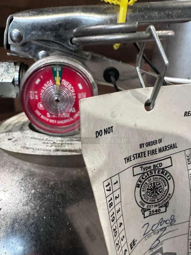 Cintas stainless steel commercial fire extinguisher, Type B:C:D, excellent condition, inspection tag visible, professionally serviced.