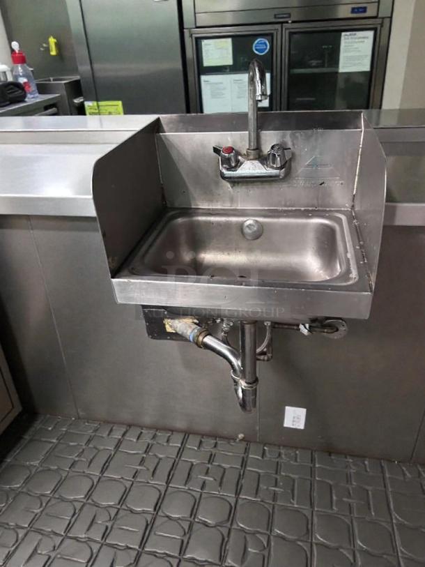 Commercial stainless steel wall-mounted hand sink with faucet and side splash, tested, in outstanding condition.