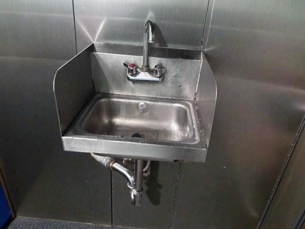 Commercial stainless steel wall-mounted hand sink with faucet and side splash, in outstanding condition, tested and ready for use.