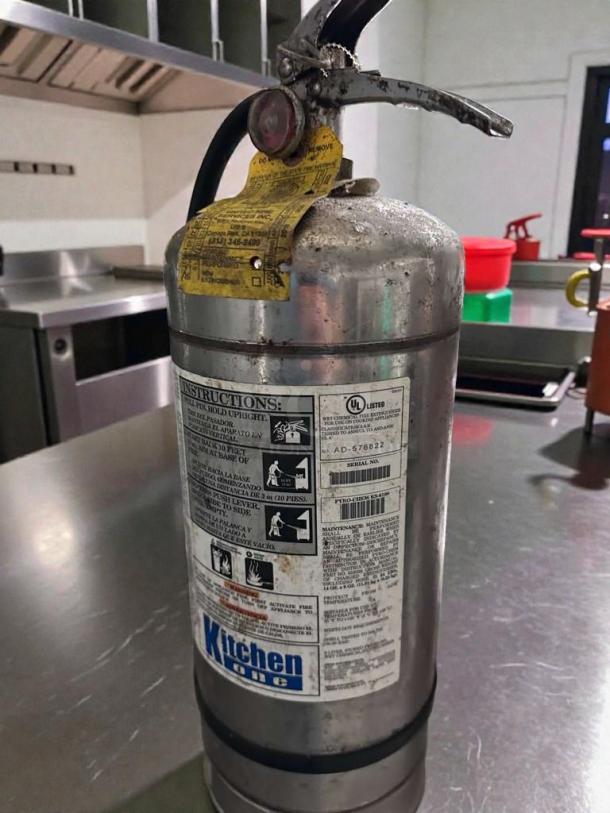 Kitchen One Class K fire extinguisher, model AD-576822, silver, tested and working, outstanding condition, instructional labels visible.