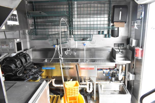 28' Wendy's fast food trailer with commercial kitchen setup, stainless steel sinks, shelving, and clear title. Ready for use.