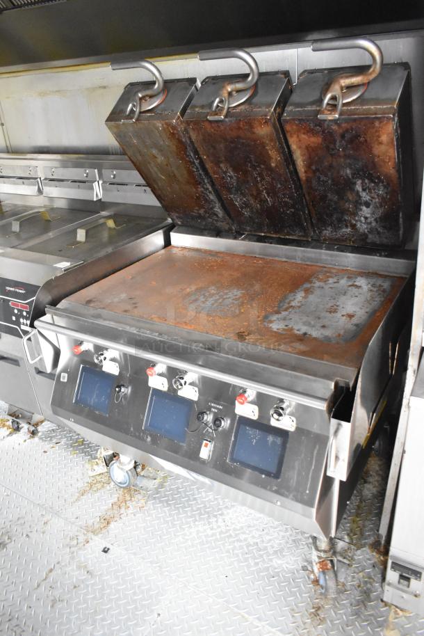 Commercial-grade grill in a Wendy's fast food trailer, featuring cooking controls and grease hood. Used, in working condition.