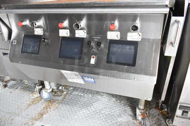 Wendy's fast food trailer interior showing control panel with display screens, red buttons, and caution labels.
