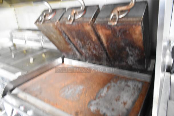 Mobile kitchen interior showing commercial-grade cooking equipment, including a Taylor electric platen grill and fryer units.