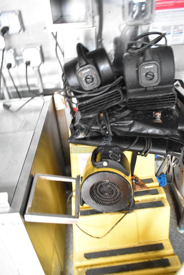 Industrial fans and equipment inside Wendy's mobile kitchen trailer, including cords and metal surfaces.