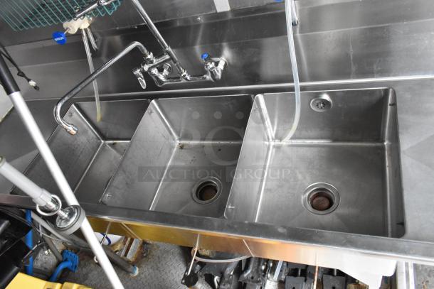 Stainless steel triple sink unit in Wendy's mobile kitchen trailer, featuring attached faucet and visible drainage, ideal for fast food preparation.