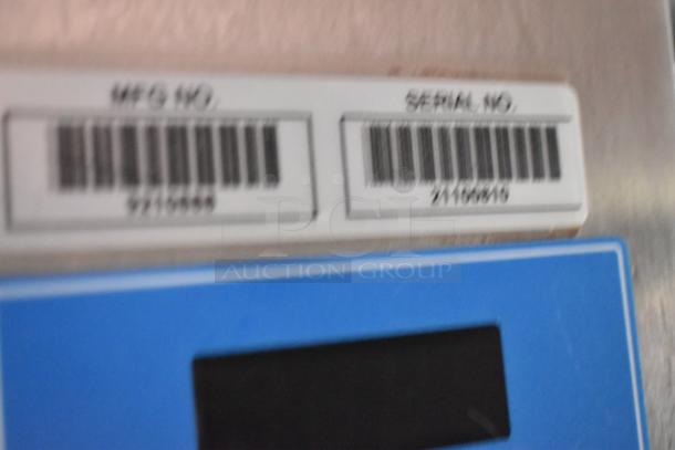 Blurred image of manufacturing and serial number labels on equipment.