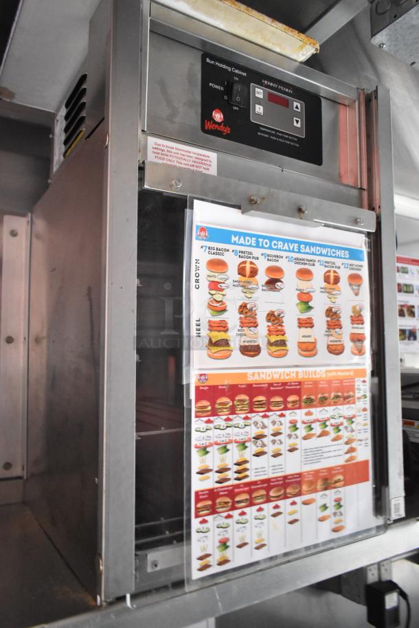 Wendy's bun holding cabinet by Henny Penny in a 28' mobile kitchen trailer, with sandwich menu displayed on the door.