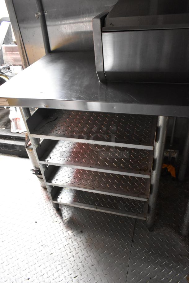 Stainless steel shelving unit in a 28' Wendy's mobile kitchen trailer. Features diamond plate shelves.