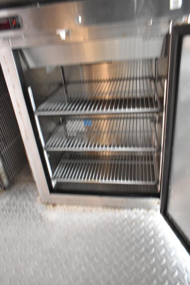 Interior of a commercial-grade cooler with metal shelving, part of a 28' Wendy's fast food trailer kitchen setup.