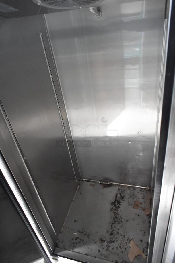Interior view of fast food trailer cooler, showing empty stainless steel shelves and floor, indicating ample storage space.