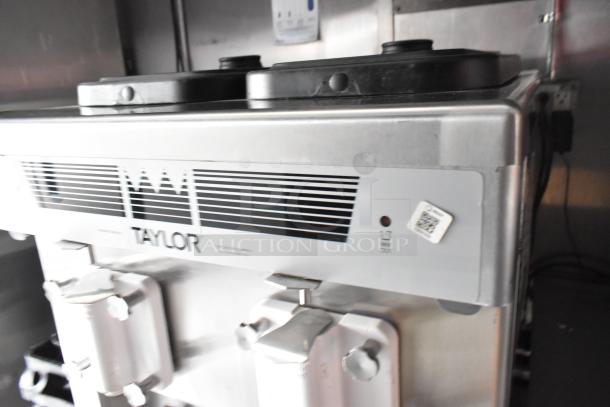 Taylor milkshake machine, stainless steel body, visible controls, in excellent condition, located in a mobile kitchen.