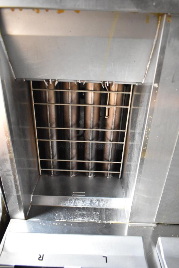 Interior of mobile kitchen's commercial CaptiveAire grease hood, showing stainless steel and grill vent detail.