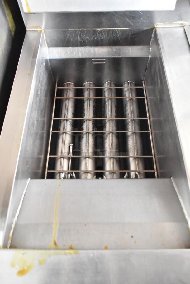Close-up of a stainless steel fryer in a Wendy's 28' fast food trailer, featuring metal tubes and wire rack, used condition.