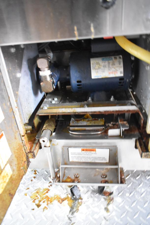 Interior view of restaurant equipment inside a Wendy's 28' fast food trailer, showcasing utility connections and motor components.