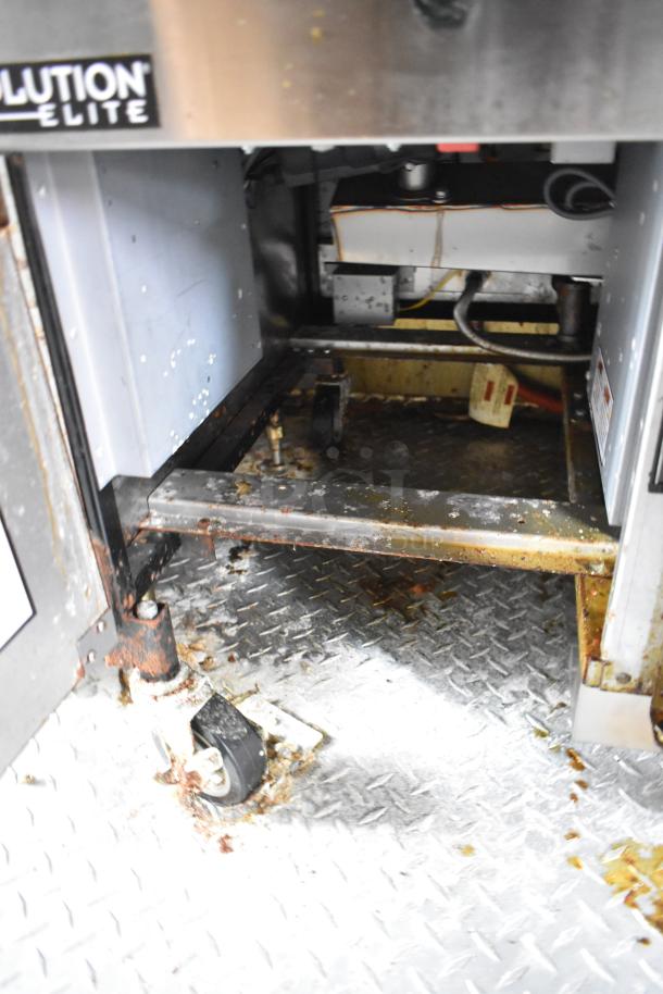Interior view of a Wendy's fast food trailer equipment compartment, showing metal framework and wheels.