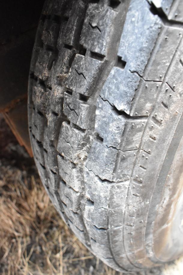 Close-up of a used tire attached to a 28' Wendy's fast food trailer. Tread shows signs of wear.