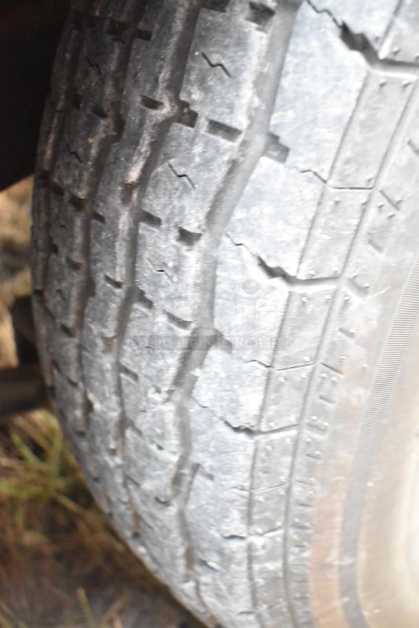 Close-up of a tire on a 28' Wendy's fast food trailer, showing tread condition. Suitable for mobile kitchen use.