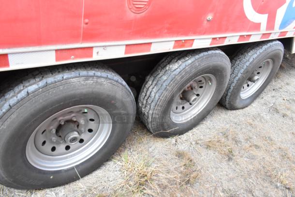 28' Wendy's mobile kitchen trailer with durable triple-axle tires, red branding, and commercial-grade equipment.