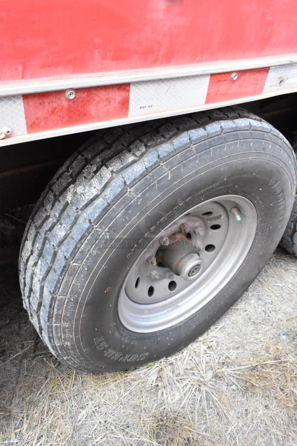 Close-up of a tire on a 28' Wendy's fast food trailer. Tire shows moderate wear; trailer features commercial kitchen equipment.