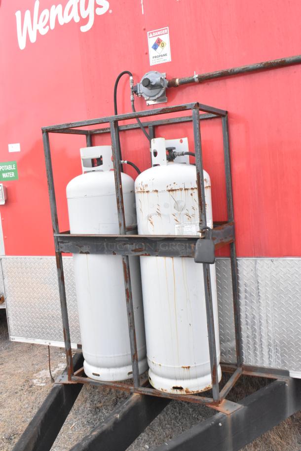 Red Wendy's fast food trailer with dual propane tanks in a metal frame. Features a safety warning label about propane use.
