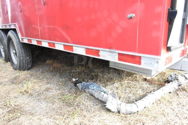 Red 28' Wendy's fast food trailer, showing side view with wheels. Includes exhaust hose on ground, metal exterior details visible.