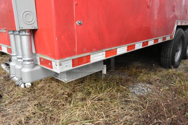 Red Wendy's fast food trailer exterior. Reflective striping, sturdy understructure, visible pipes. Ready for mobile kitchen use.