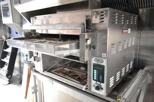 Mobile kitchen trailer interior with Nieco Charbroiler Hamburger Grill, commercial stainless steel equipment, well-maintained.