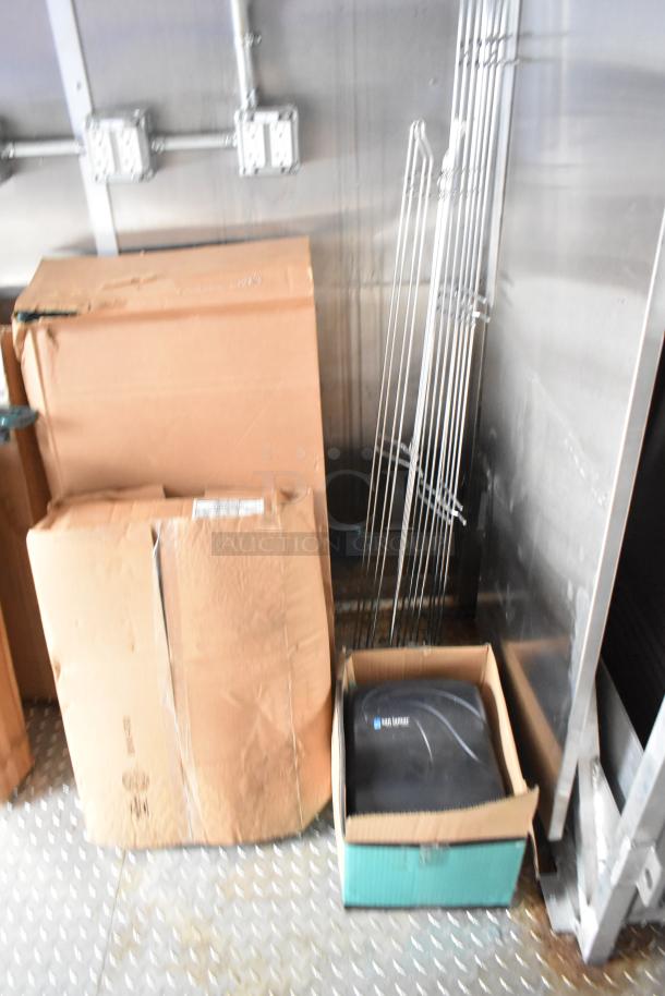 24' Rock Solid Cargo fast food trailer interior with equipment boxes and metal racks, ready for corporate use.